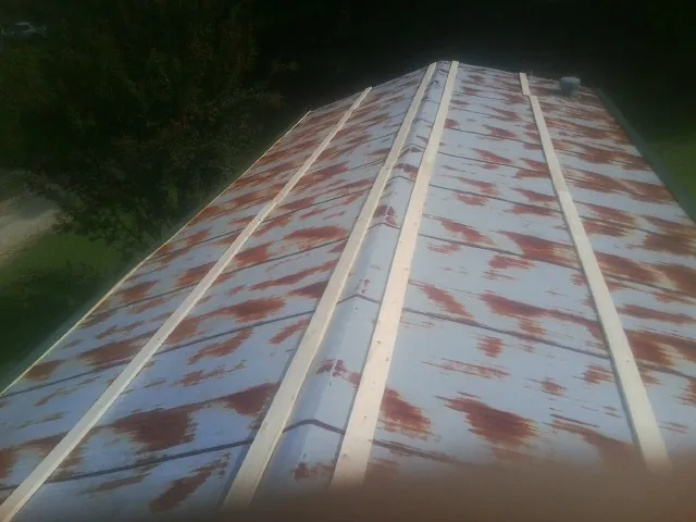 Rusted metal roof panels with new wood purlins before replacement — Storm Damage Roof Repair in Chuckey by Roofing Brothers