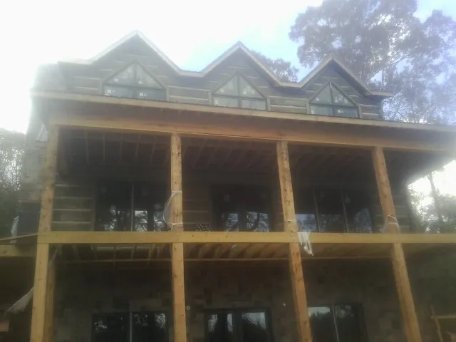 Dormers and porch framing on a large log home under construction — Roof Coating work by our crew in Chuckey