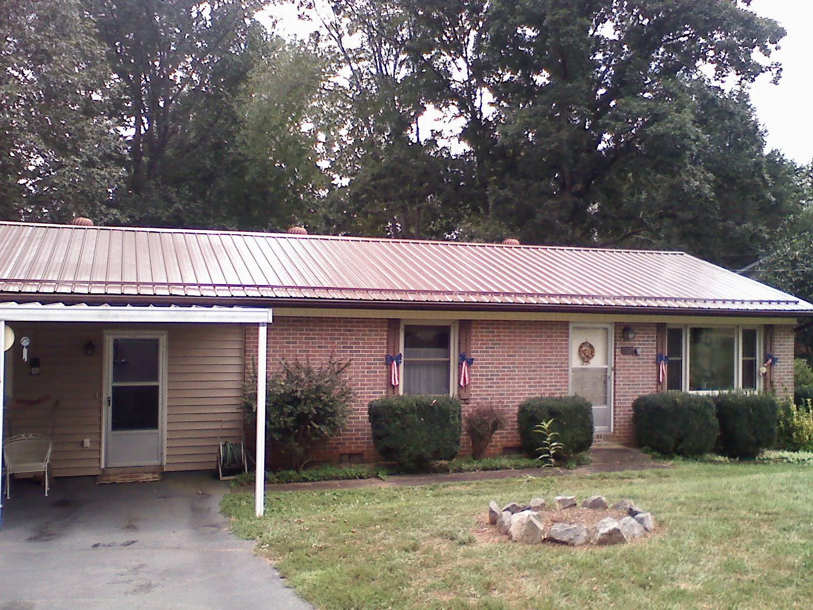 Bronze metal roof and carport on a brick ranch home — Roof Repair work by our crew in Chuckey